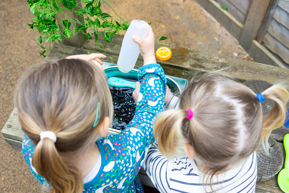 two girls playing outside at nursery